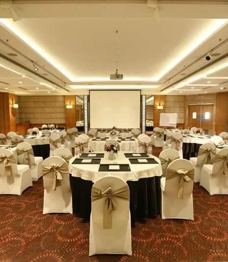 Belva Ballroom set with round tables and a projection screen